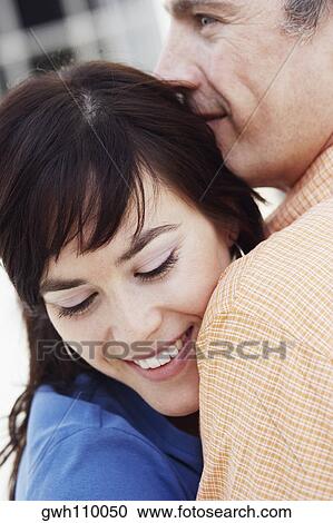 Close-up of a mature man and a young woman hugging each other View Large Photo Image Stock Image - Close-up of a mature man and a young woman hugging each other. Fotosearch