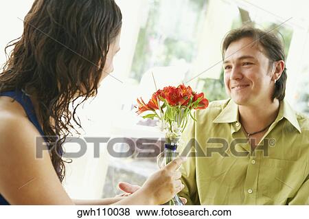 Stock Photo - Close-up of a young woman and a mid adult man smiling in a restaurant. Fotosearch