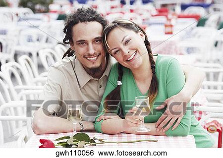 Portrait of a young couple sitting together at a sidewalk cafe View Large Photo Image Stock Photograph - Portrait of a young couple sitting together at a sidewalk cafe . Fotosearch
