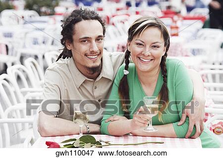 Young couple sitting together at a sidewalk cafe View Large Photo Image Stock Photo - Young couple sitting together at a sidewalk cafe . Fotosearch