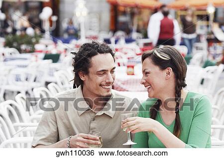 Young couple sitting together at a sidewalk cafe View Large Photo Image Stock Photograph - Young couple sitting together at a sidewalk cafe . Fotosearch