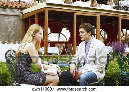 Young couple sitting together outdoors View Large Photo Image Stock Photo - Young couple sitting together outdoors . Fotosearch