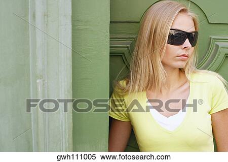 Close-up of a young woman leaning against a wall View Large Photo Image Stock Photography - Close-up of a young woman leaning against a wall . Fotosearch