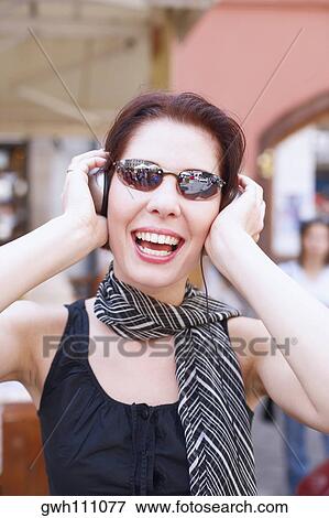 Stock Photo - Close-up of a young woman wearing headphones . Fotosearch