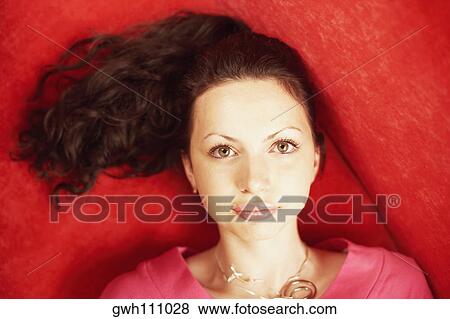Stock Photo - High angle view of a young woman lying down. Fotosearch