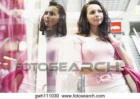 Low angle view of a young woman on an escalator View Large Photo Image Stock Image - Low angle view of a young woman on an escalator . Fotosearch