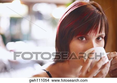 Portrait of a young woman drinking coffee View Large Photo Image Picture - Portrait of a young woman drinking coffee . Fotosearch