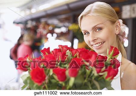 Portrait of a young woman holding a bouquet of flowers View Large Photo Image Stock Image - Portrait of a young woman holding a bouquet of flowers . Fotosearch