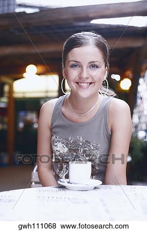 Stock Photo - Portrait of a young woman smiling in a restaurant . Fotosearch