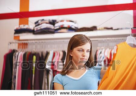 Stock Image - Young woman in a clothing store. Fotosearch