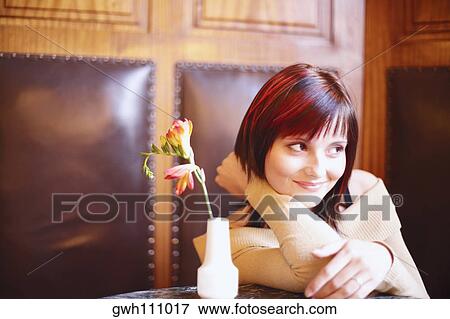Young woman sitting in a restaurant View Large Photo Image Stock Photo - Young woman sitting in a restaurant . Fotosearch