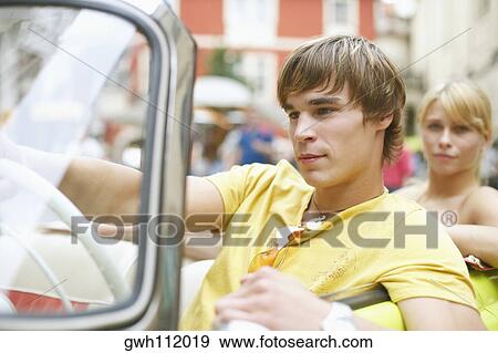 Close-up of a young man sitting in a car View Large Photo Image Stock Photo - Close-up of a young man sitting in a car . Fotosearch