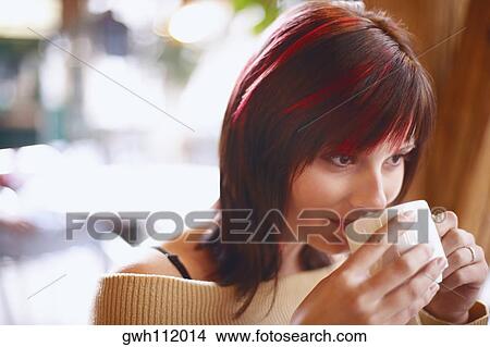 Close-up of a young woman drinking coffee View Large Photo Image Picture - Close-up of a young woman drinking coffee . Fotosearch