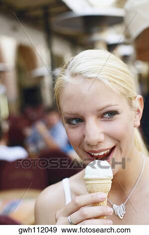 Close-up of a young woman holding an ice-cream cone View Large Photo Image Stock Photo - Close-up of a young woman holding an ice-cream cone. Fotosearch