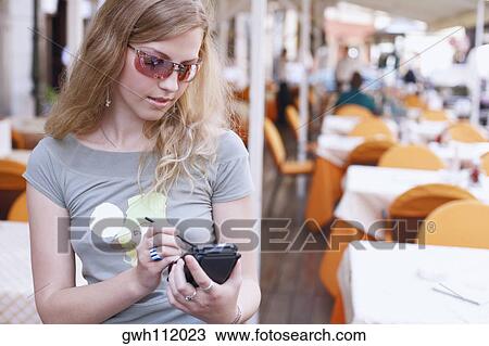 Close-up of a young woman operating a personal data assistant View Large Photo Image Stock Image - Close-up of a young woman operating a personal data assistant . Fotosearch