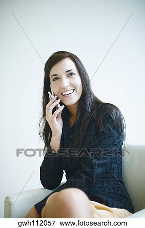 Close-up of a young woman talking on a mobile phone View Large Photo Image Stock Photo - Close-up of a young woman talking on a mobile phone. Fotosearch