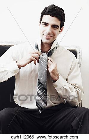 Portrait of a businessman tying his tie View Large Photo Image Stock Photography - Portrait of a businessman tying his tie. Fotosearch