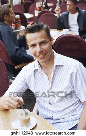 Portrait of a mid adult man having tea in a restaurant View Large Photo Image Stock Photo - Portrait of a mid adult man having tea in a restaurant. Fotosearch