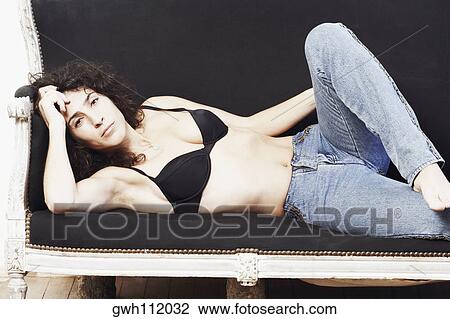 Portrait of a mid adult woman lying on a couch View Large Photo Image Stock Image - Portrait of a mid adult woman lying on a couch. Fotosearch