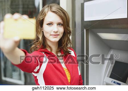 Portrait of a teenage girl holding an ATM card View Large Photo Image Stock Photography - Portrait of a teenage girl holding an ATM card . Fotosearch