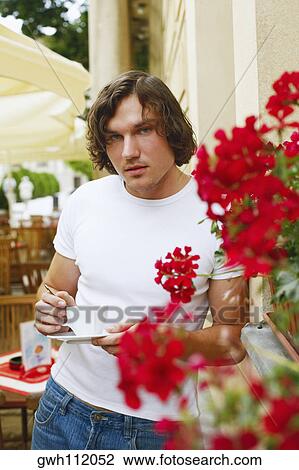 Portrait of a young man standing in a restaurant View Large Photo Image Stock Image - Portrait of a young man standing in a restaurant . Fotosearch
