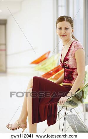 Stock Image - Portrait of a young woman sitting in an armchair. Fotosearch