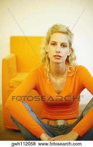 Portrait of a young woman sitting on the floor View Large Photo Image Stock Photo - Portrait of a young woman sitting on the floor. Fotosearch