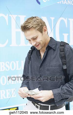 Stock Photography - Young man counting money. Fotosearch