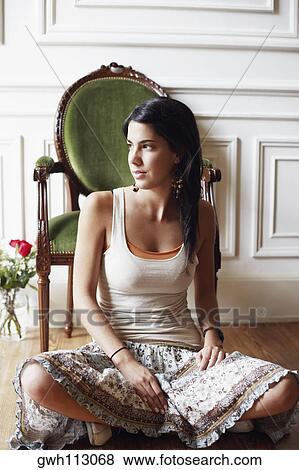 Close-up of a young woman sitting on the floor View Large Photo Image Stock Photo - Close-up of a young woman sitting on the floor. Fotosearch