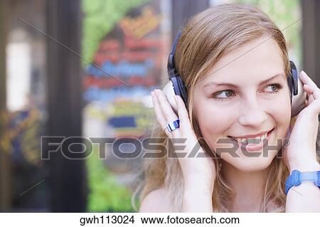Picture - Close-up of a young woman wearing headphones. Fotosearch