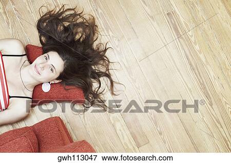 High angle view of a young woman lying on the floor View Large Photo Image Stock Photo - High angle view of a young woman lying on the floor. Fotosearch