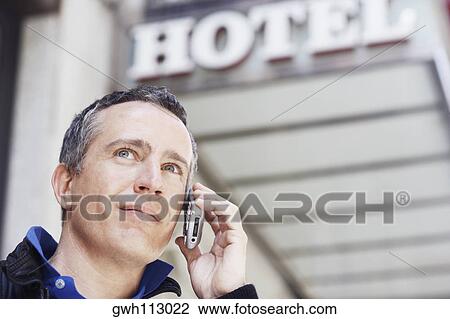 Low angle view of a mature man talking on a mobile phone View Large Photo Image Stock Image - Low angle view of a mature man talking on a mobile phone . Fotosearch