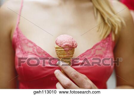 Mid section view of a woman holding an ice-cream cone View Large Photo Image Stock Image - Mid section view of a woman holding an ice-cream cone. Fotosearch
