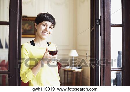 Portrait of a mid adult woman holding a glass of red wine and smiling View Large Photo Image Stock Photo - Portrait of a mid adult woman holding a glass of red wine and smiling. Fotosearch