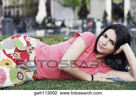 Portrait of a mid adult woman lying on the lawn View Large Photo Image Stock Image - Portrait of a mid adult woman lying on the lawn . Fotosearch