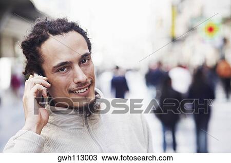 Stock Image - Portrait of a young man talking on a mobile phone . Fotosearch