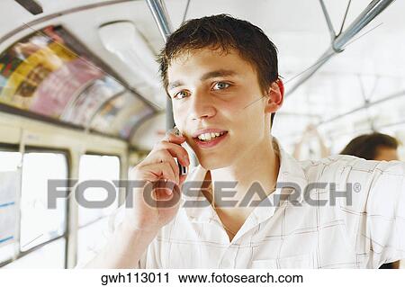 Portrait of a young man talking on a mobile phone View Large Photo Image Stock Image - Portrait of a young man talking on a mobile phone . Fotosearch