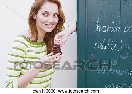 Portrait of a young woman holding a chocolate View Large Photo Image Stock Image - Portrait of a young woman holding a chocolate. Fotosearch