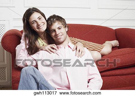 Stock Photo - Portrait of a young woman leaning over a young man from behind. Fotosearch