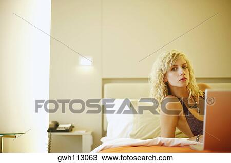 Stock Image - Portrait of a young woman using a laptop. Fotosearch