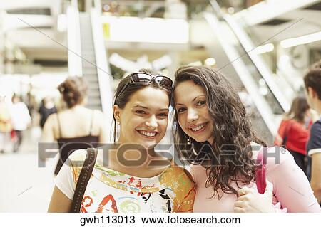 Stock Image - Portrait of two young women smiling . Fotosearch