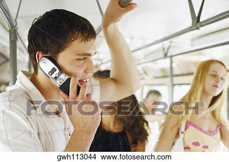 Picture - Side profile of a young man talking on a mobile phone . Fotosearch
