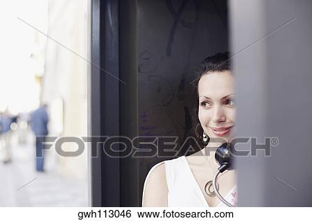 Young woman in a telephone booth View Large Photo Image Stock Photograph - Young woman in a telephone booth. Fotosearch