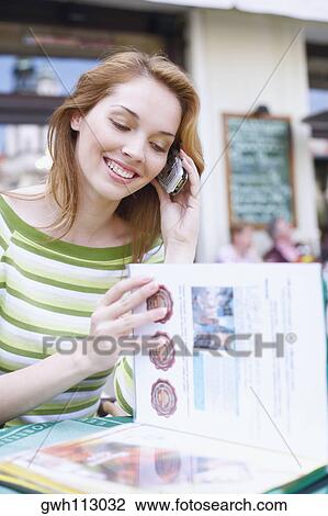 Young woman talking on a mobile phone in a restaurant View Large Photo Image Stock Image - Young woman talking on a mobile phone in a restaurant . Fotosearch