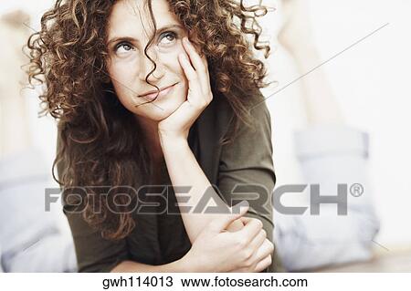 Close-up of a mid adult woman lying on the floor with her hand on her chin View Large Photo Image Stock Image - Close-up of a mid adult woman lying on the floor with her hand on her chin. Fotosearch
