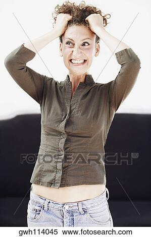 Close-up of a mid adult woman pulling her hair in excitement View Large Photo Image Stock Photography - Close-up of a mid adult woman pulling her hair in excitement. Fotosearch
