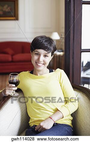 Portrait of a mid adult woman holding a glass of red wine and smiling View Large Photo Image Stock Photo - Portrait of a mid adult woman holding a glass of red wine and smiling. Fotosearch
