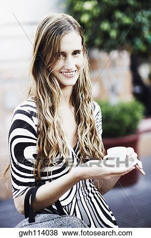 Portrait of a young woman holding a cup of tea View Large Photo Image Stock Photo - Portrait of a young woman holding a cup of tea . Fotosearch
