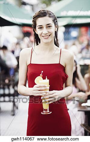 Stock Photo - Portrait of a young woman holding a glass of juice . Fotosearch