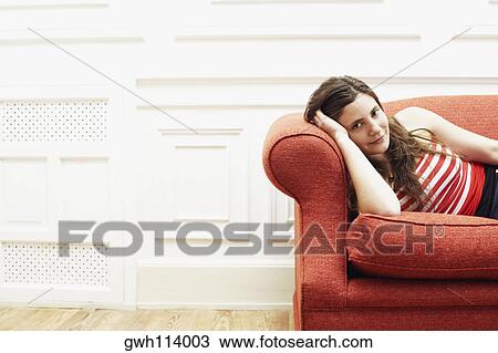 Portrait of a young woman resting on a couch View Large Photo Image Stock Image - Portrait of a young woman resting on a couch. Fotosearch
